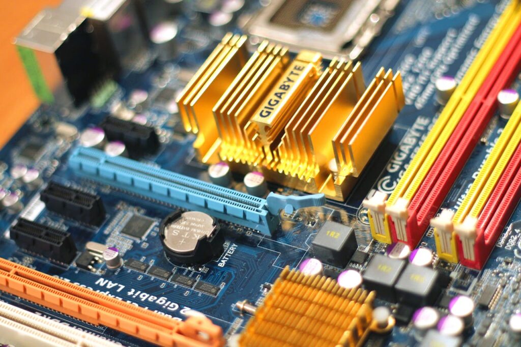 technology-computer-chips-gigabyte On this photo a computer mainboard manufactured by Gigabyte is visible. It features different sockets, connectors, coolers, heatpipes, the mainboard battery, DDR memory ram slots and the processor socket.